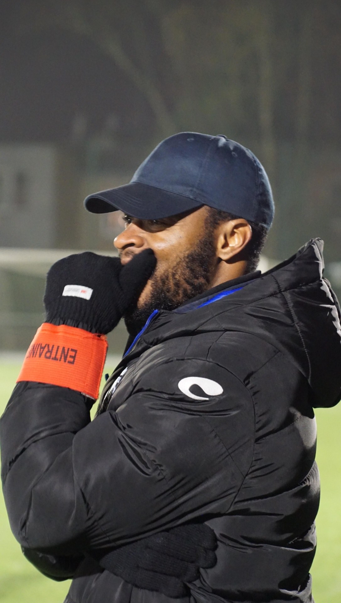 Coach CAP FOOT CONSEILS concentré pendant une séance d'entraînement, brassard d'entraîneur au bras